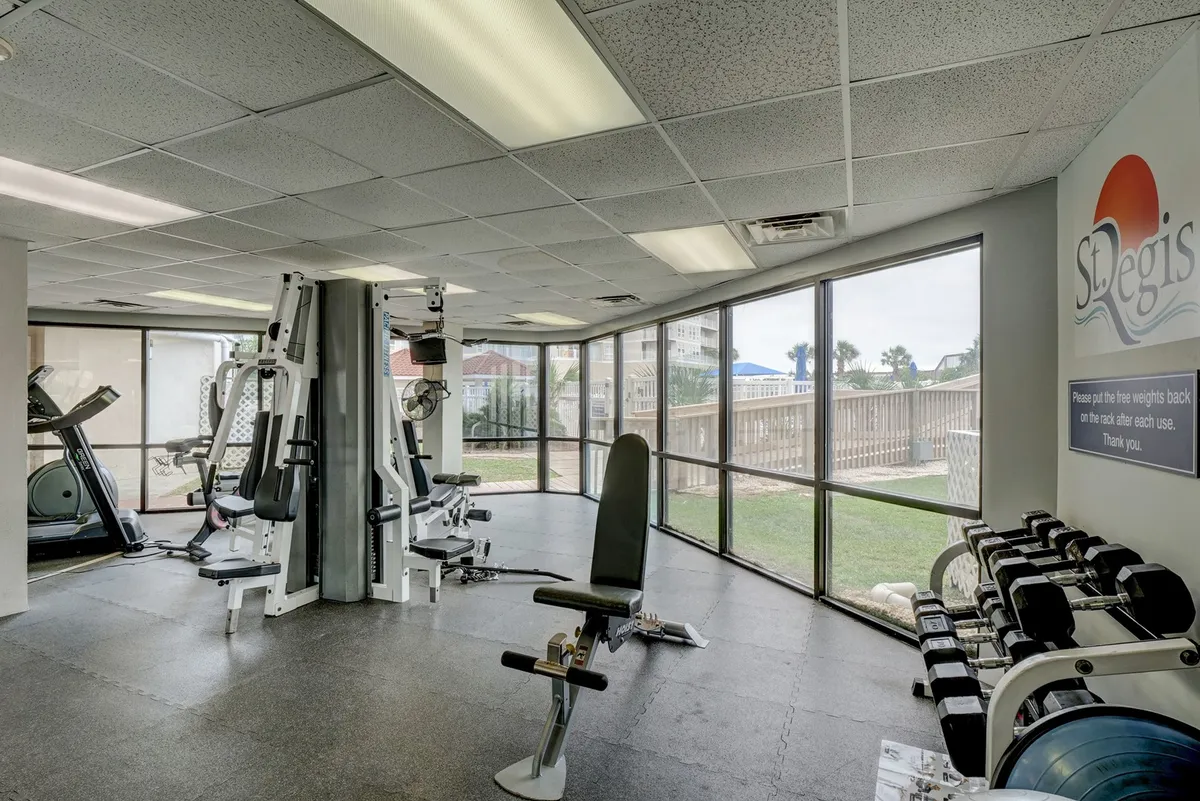 A well-equipped fitness center with modern exercise machines, free weights, and large windows allowing natural light to flood the space. The atmosphere is active and motivational, perfect for couples looking to relax or energize together.